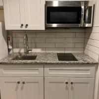 A small kitchen with a sink , microwave , and stove top oven.