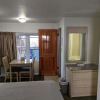 A hotel room with a bed , dresser , table and chairs.