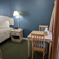 A hotel room with a bed , table and chairs.