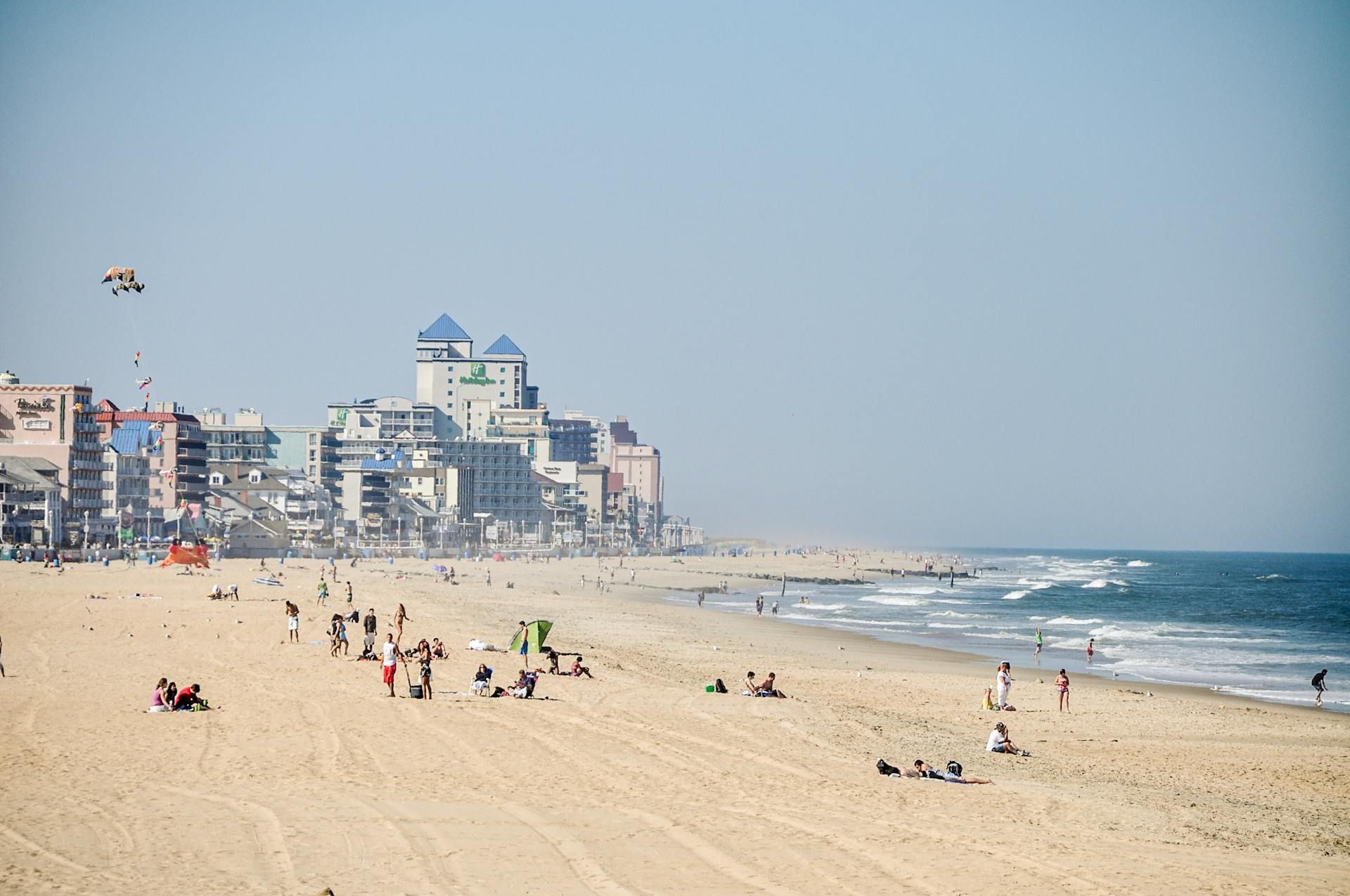 A beach with a lot of people and buildings in the background