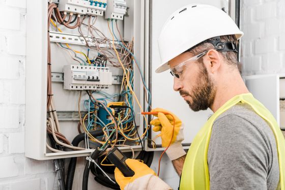 An electrician is working on a breaker box.