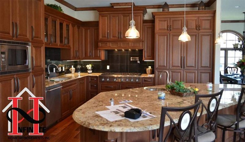 Spacious kitchen with dark wood cabinets, granite island, pendant lights, and tiled backsplash