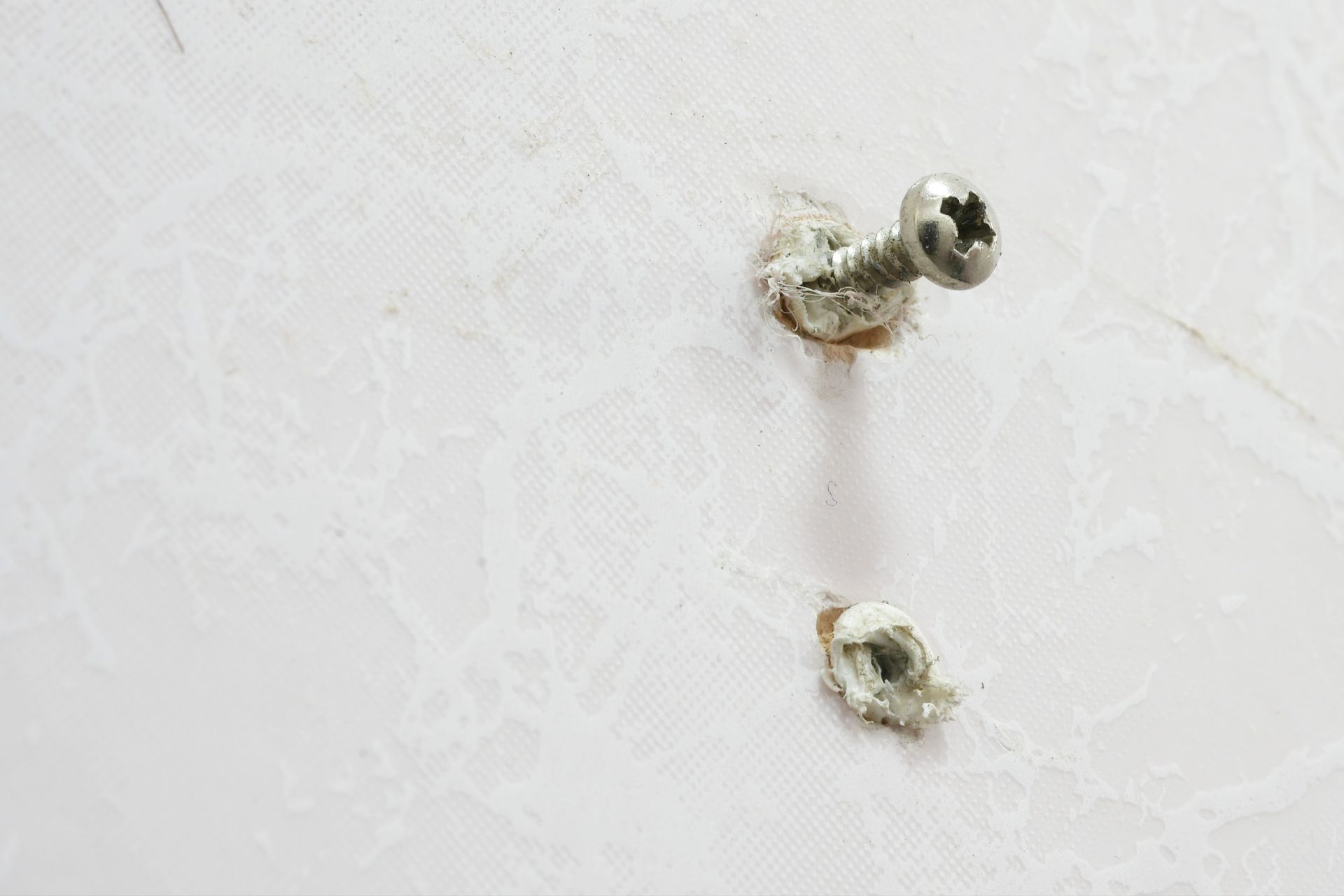 Threaded nuts screw into plastic anchors.