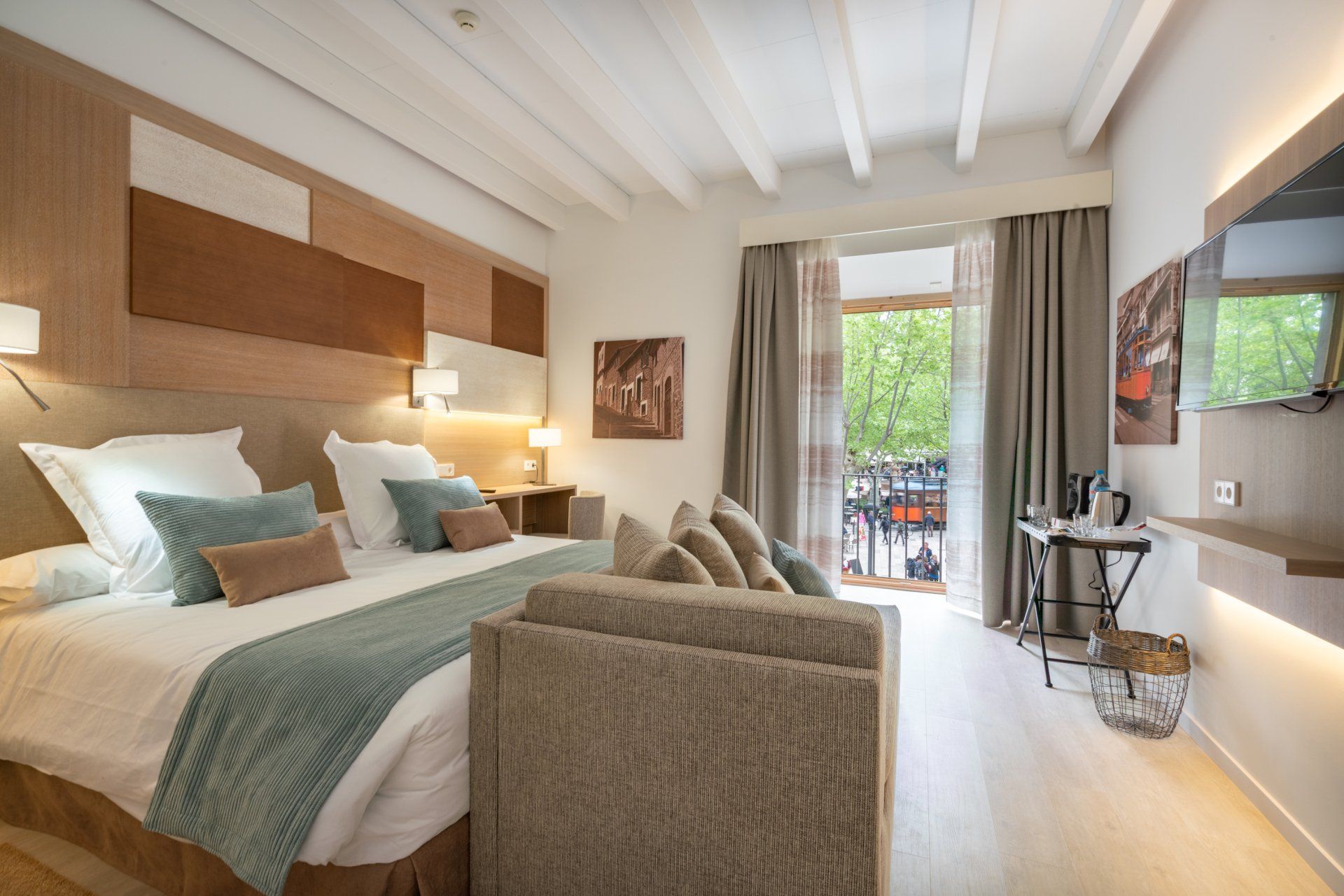 Habitación de hotel con cama king size, sofá y balcón.