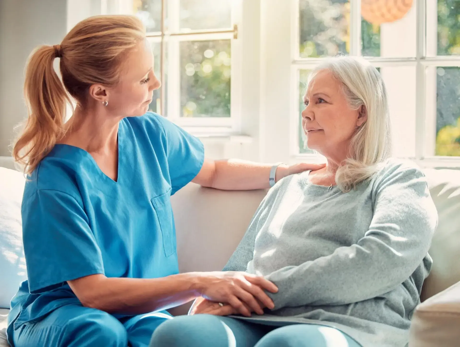 Caregiver speaking with an elderly resident in a comfortable room