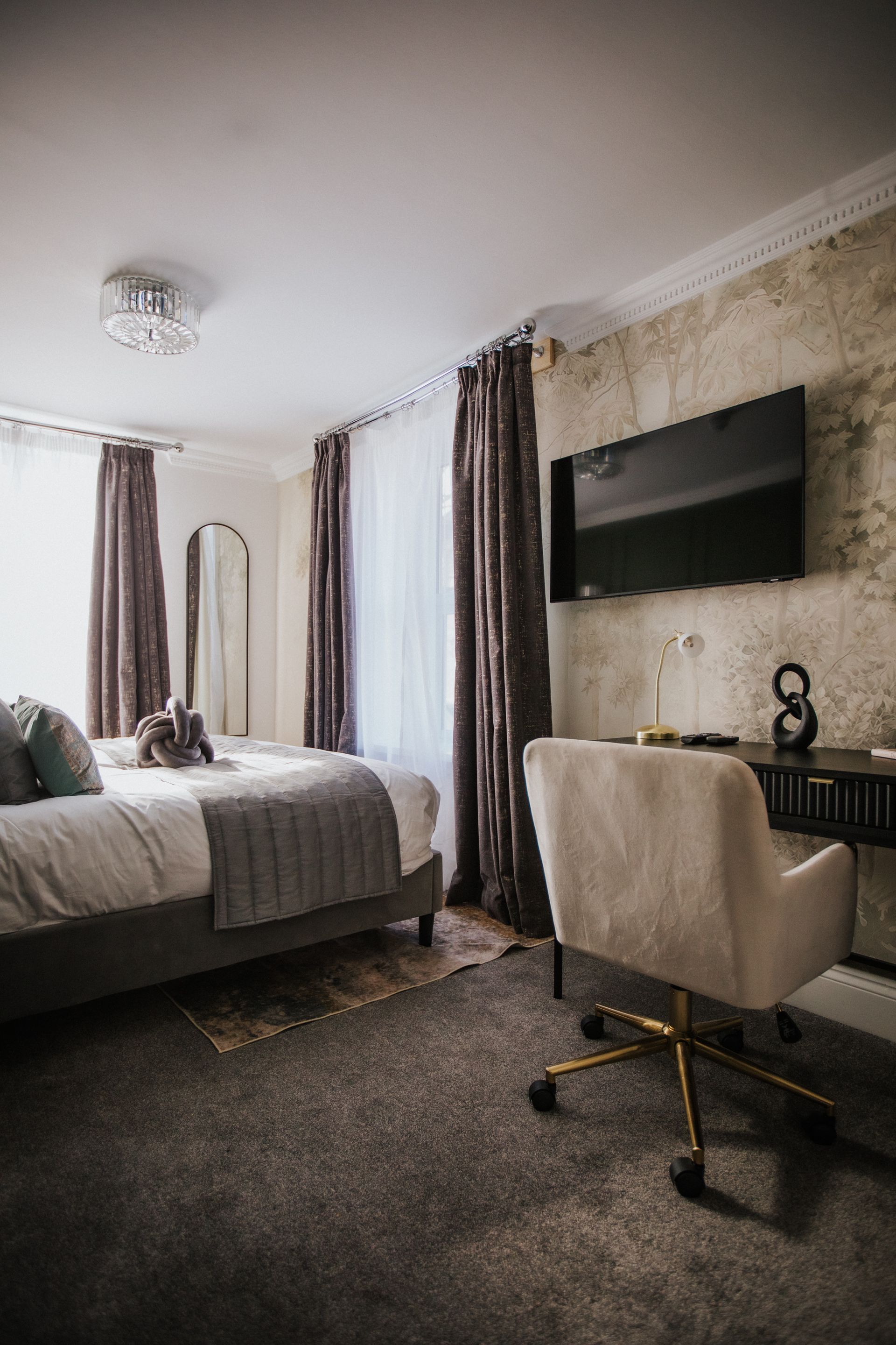Bedroom with a bed, vanity, and a TV with Netflix on the screen. The walls are a reddish-brown color.