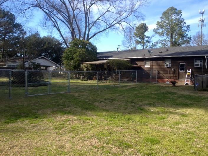 chain link fence on side of brown house