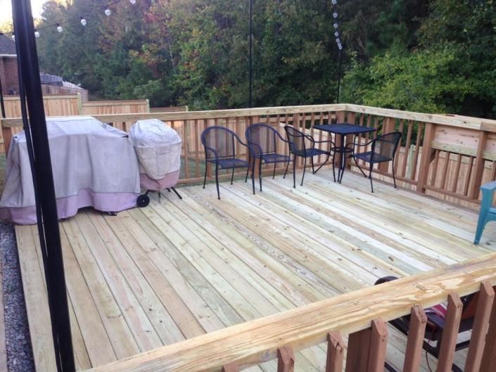 completed deck with tables and chairs and covered up grill