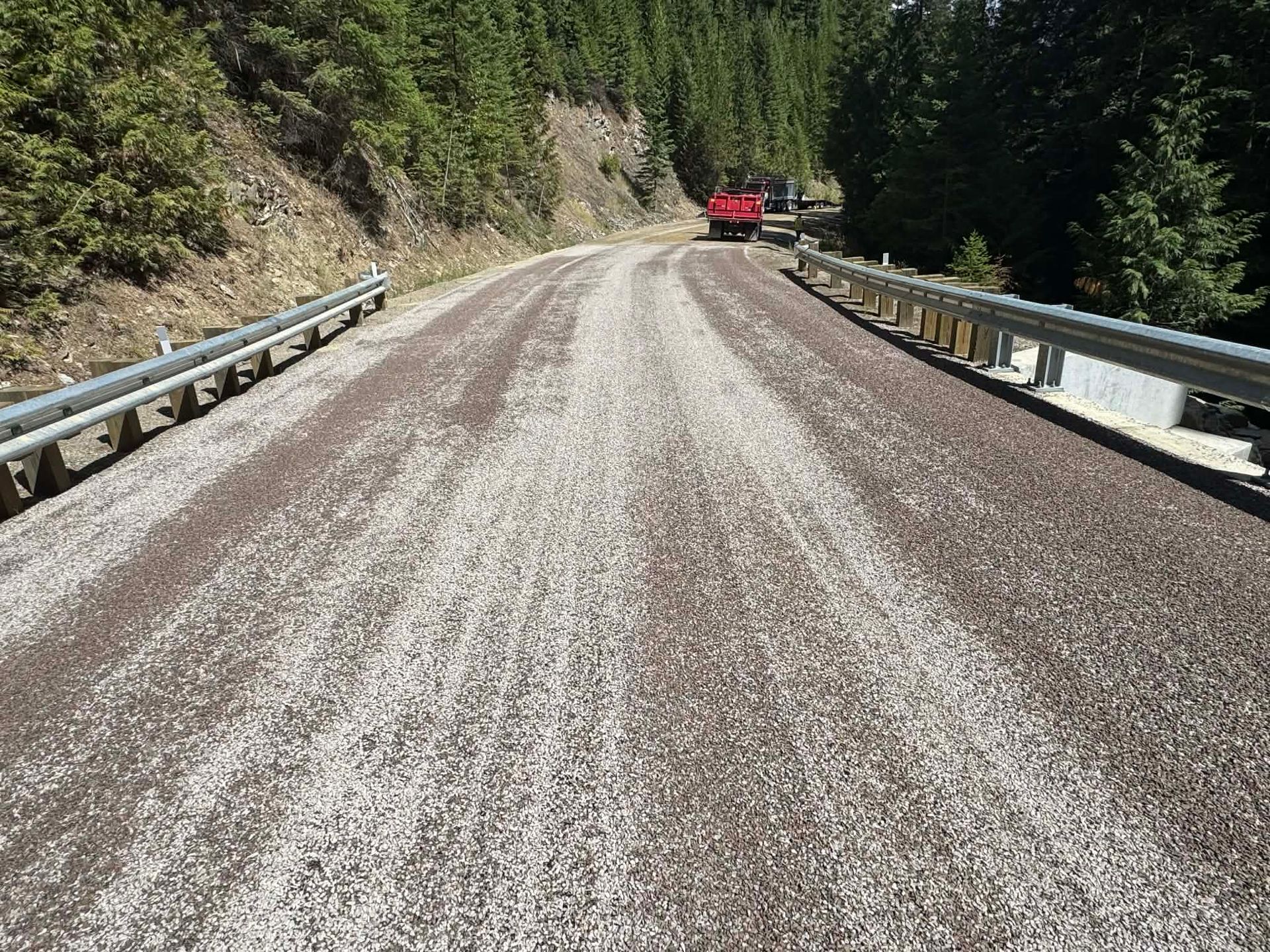 New chip seal roadway application on a winding mountain road in Great Falls, Montana