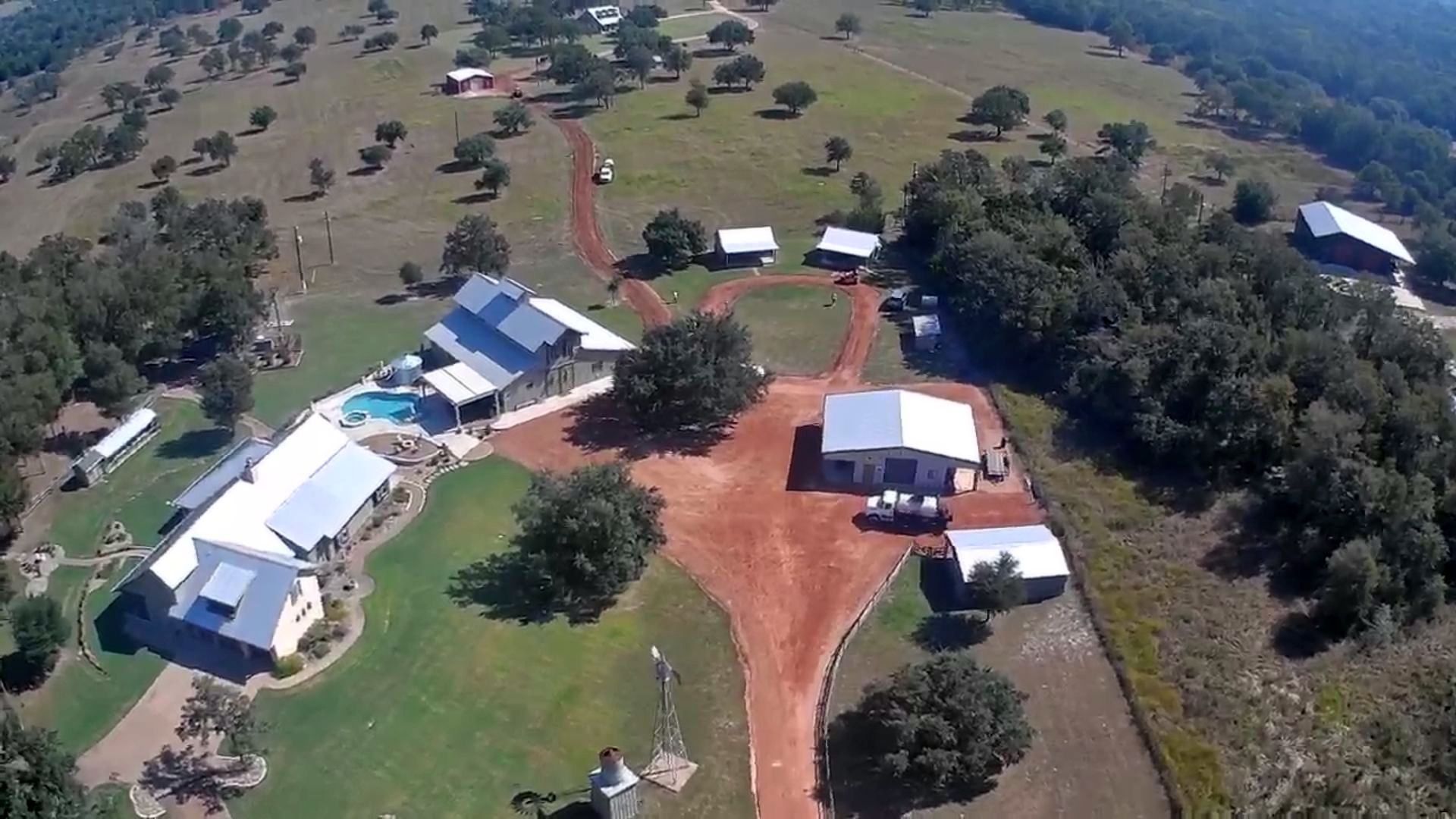 Here a before image of a farm in a rural area. The driveway is a dirt road leading up to the house. 