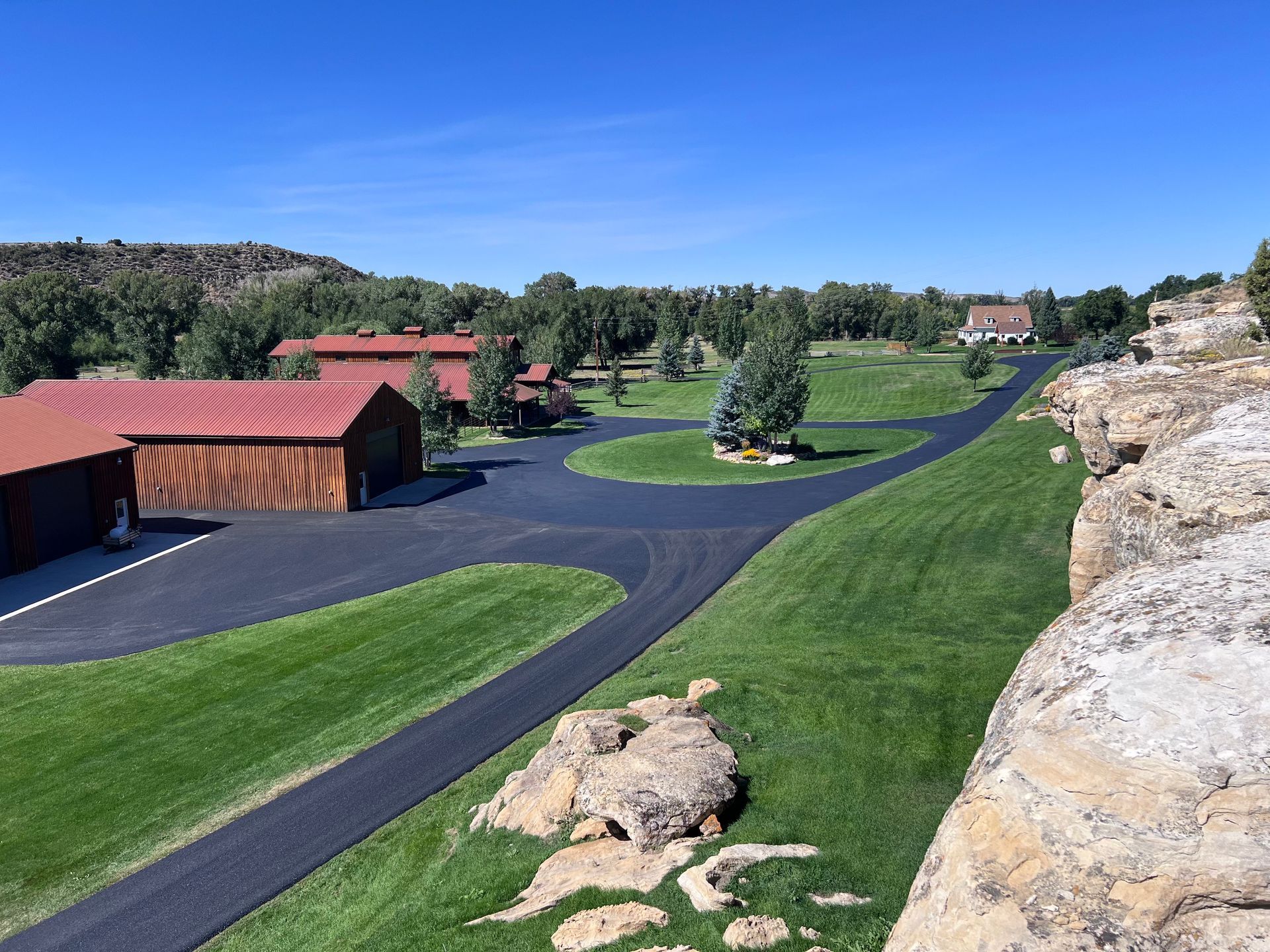 Residential asphalt driveway paving project in Great Falls, Montana with smooth curved blacktop installation