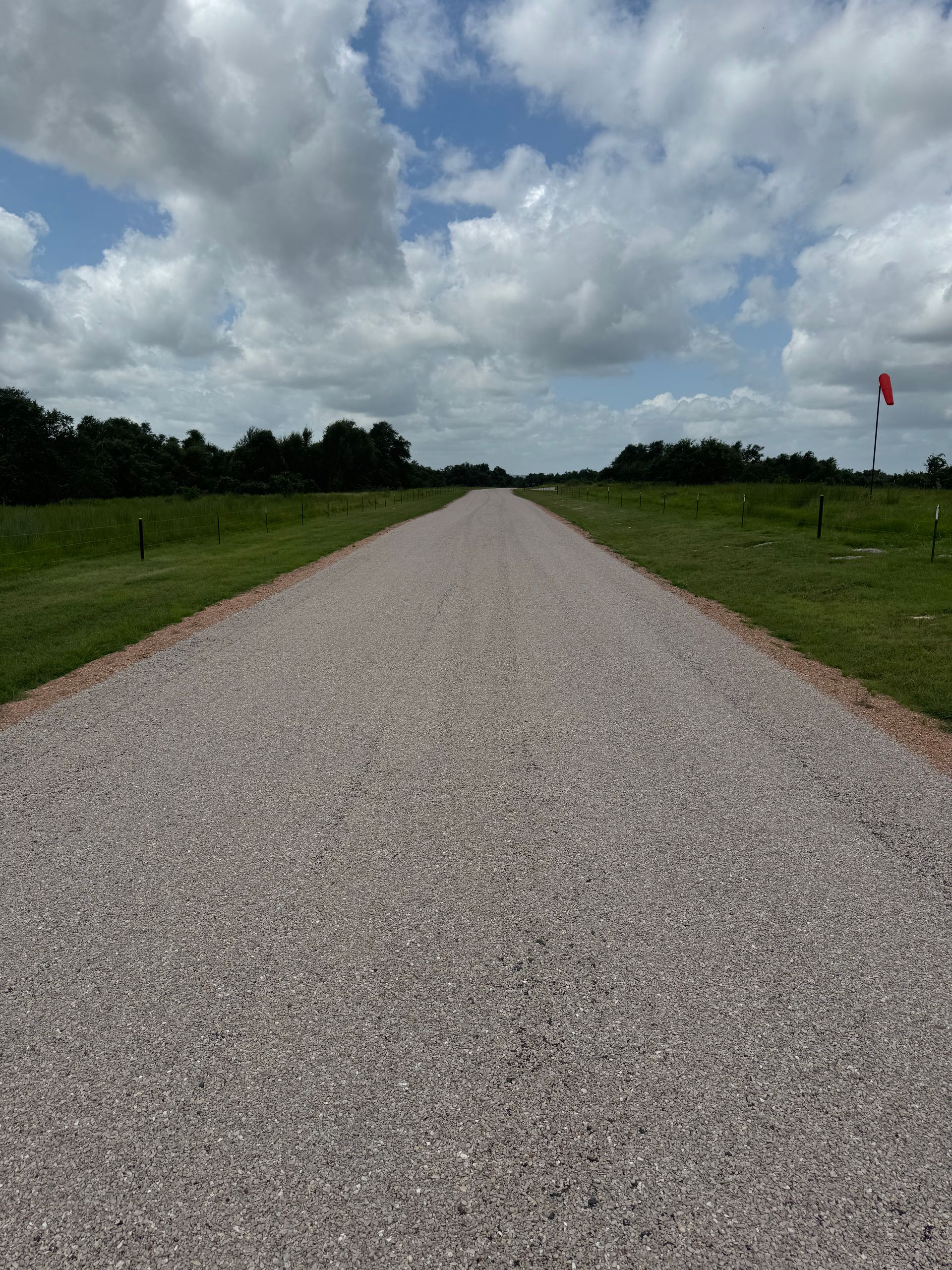 Rural road chip seal paving project with newly sealed surface in Great Falls, MT