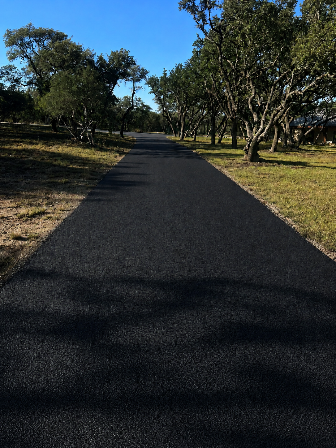 Rural road chip seal paving project with newly sealed surface in Bozeman, MT