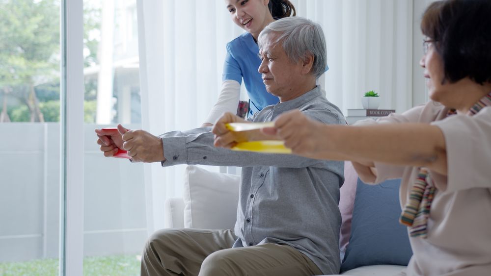 Three People Exercising With Resistance Bands — XL Care in Mount Louisa, QLD