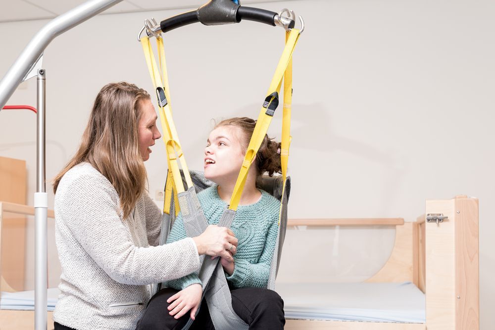 Caregiver Helping a Child in a Hospital Lift Sling — XL Care in Ingham, QLD
