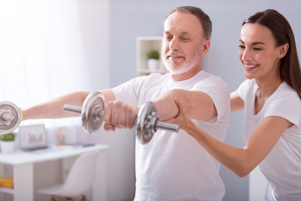 Two People Exercising With Dumbbells — XL Care in Mount Louisa, QLD