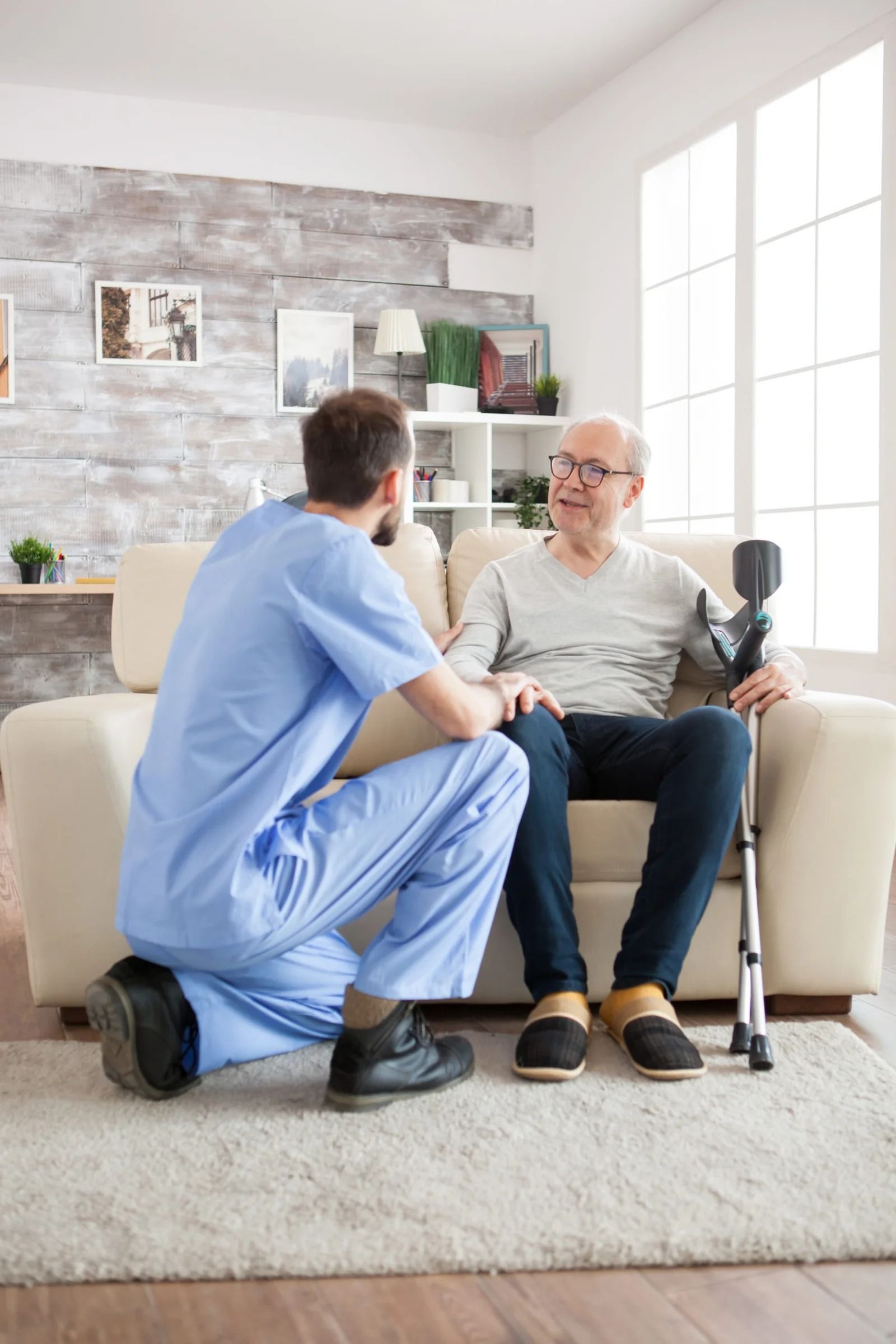 Caregiver Kneels Beside an Older Adult — XL Care in Mount Louisa, QLD