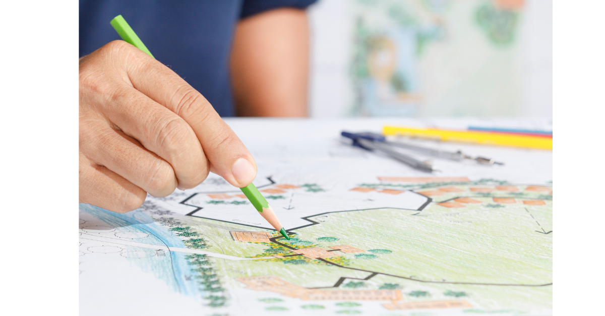 Hand holding green pencil pointing at map.