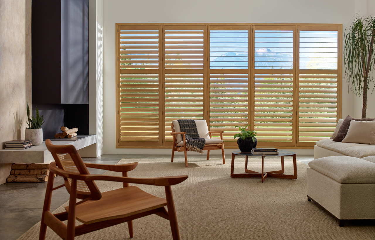 Hunter Douglas Palm Beach™ Polysatin™ Vinyl Shutters on a sliding door in a traditional living room near Coeur d'Alene, Idaho (ID)