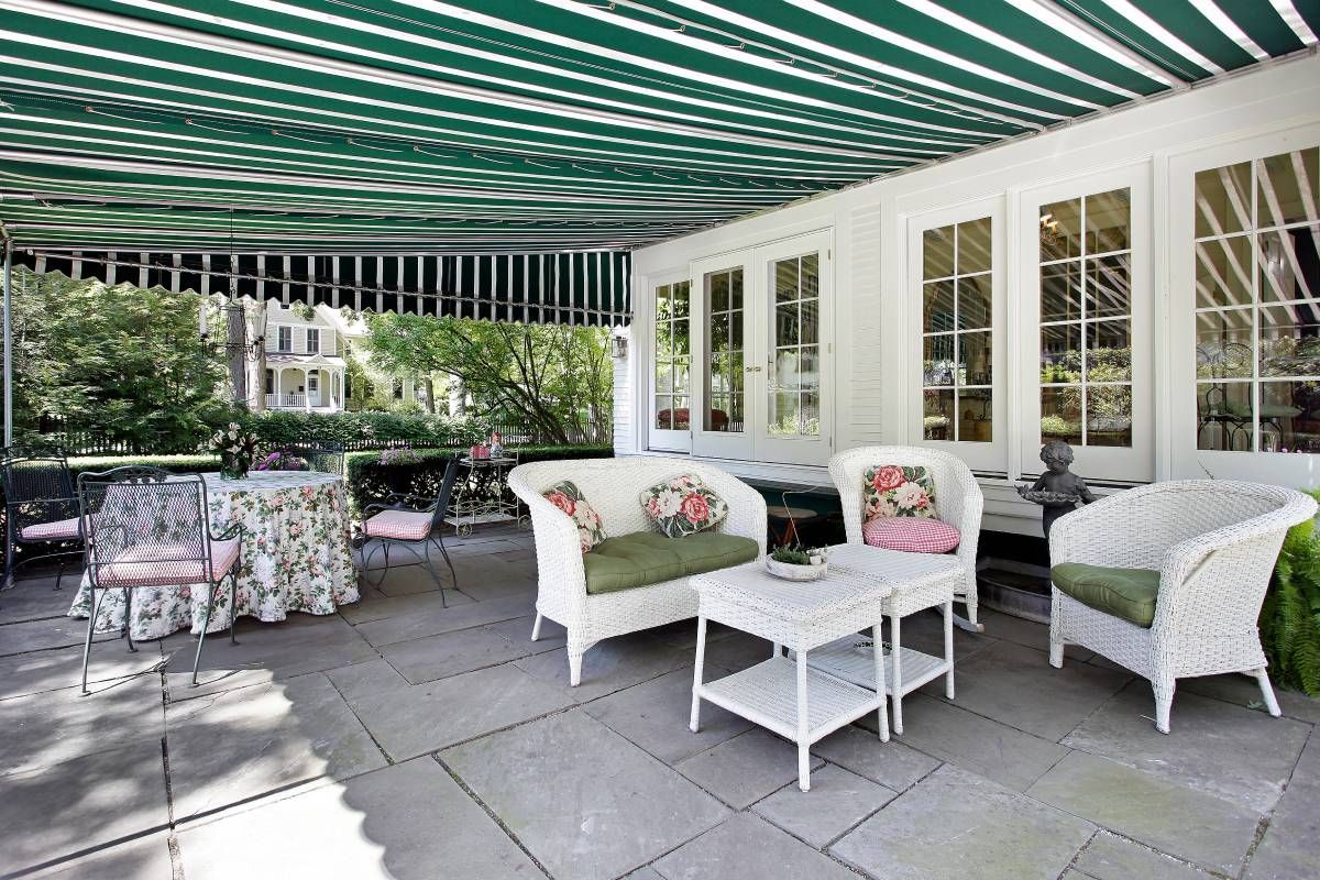 Green and white awning blocking UV rays from the floral green and pink outdoor furniture at The Blind Guy - Coeur d'Alene near Coeur d'Alene, ID