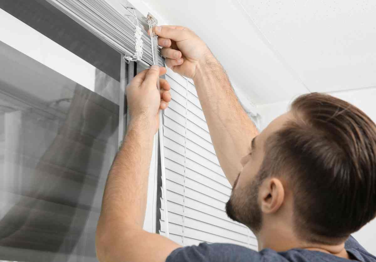 A professional installing custom and new window treatments near Coeur d'Alene, ID, in a residential home