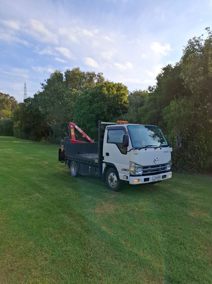 A tow truck is parked in a grassy field.