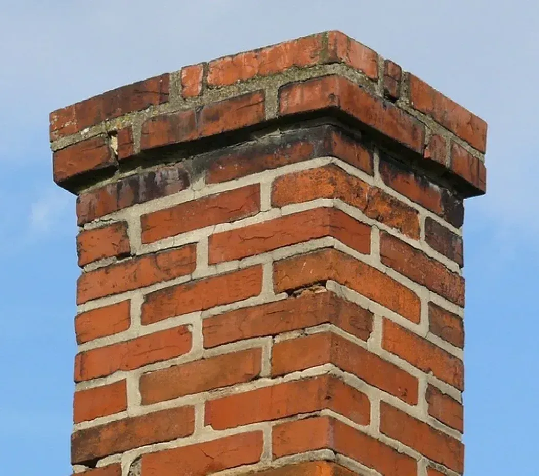 A brick chimney with a blue sky in the background