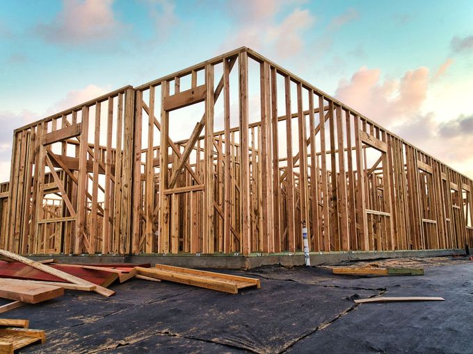A large wooden structure is being built on a construction site.