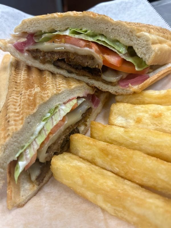 A close up of a sandwich and french fries on a table.