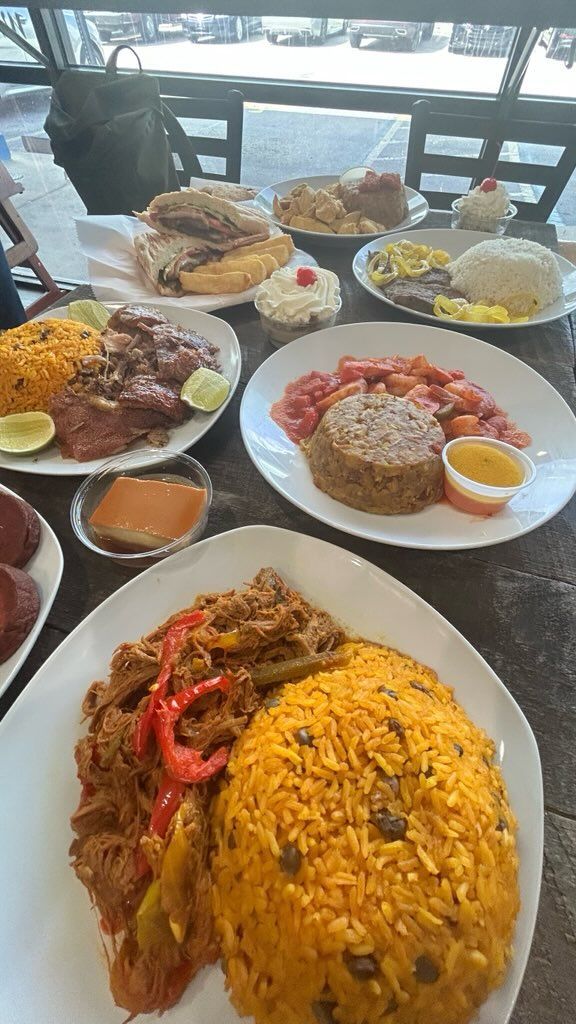A table topped with plates of food including rice and meat.