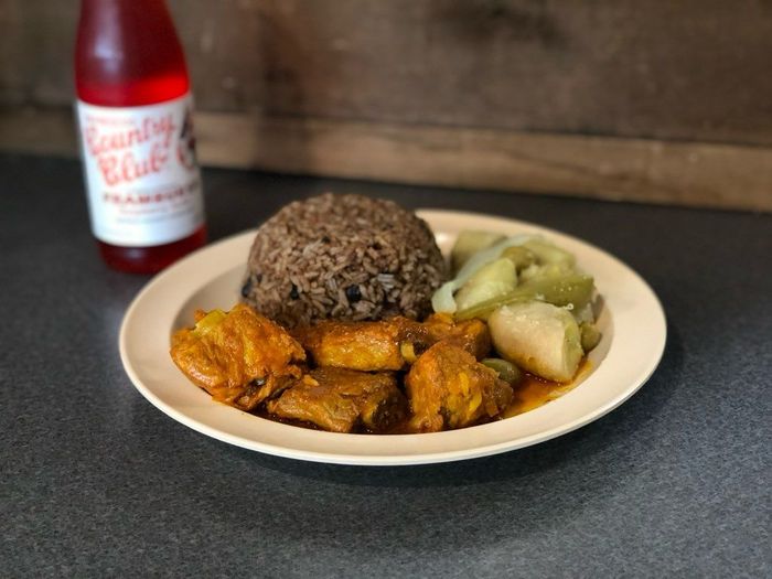 A plate of food next to a bottle of country club soda