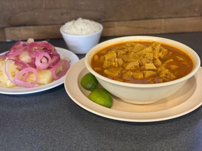 A bowl of soup and a plate of food on a table.