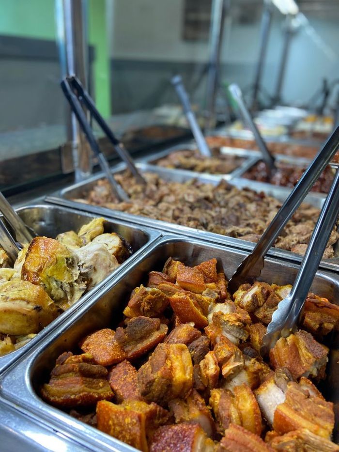 A buffet line filled with lots of food and tongs.