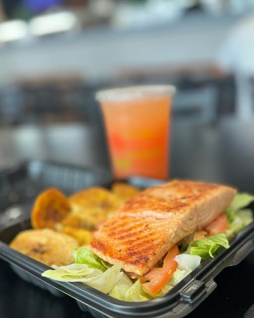 A tray of food with a drink in the background