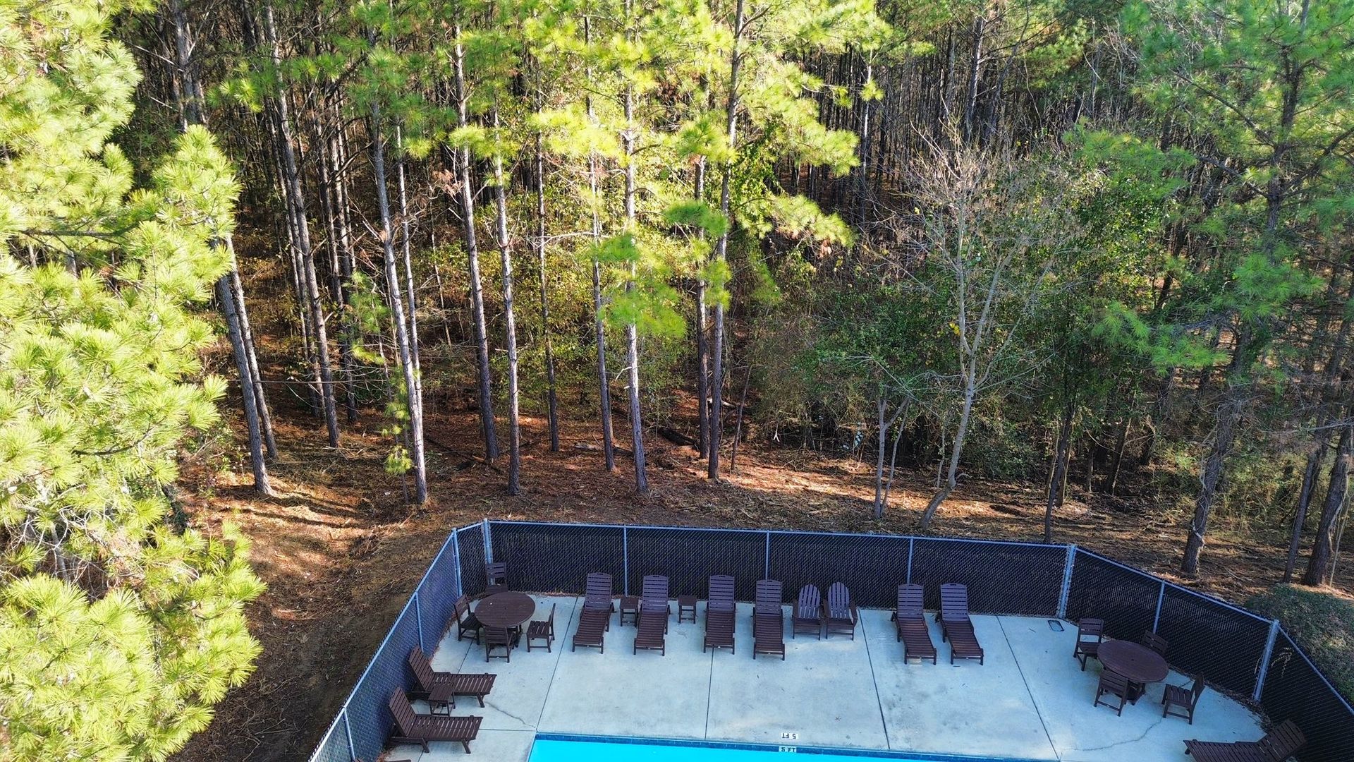 A modern tiered garden with gray retaining walls, wood-slat panels, built-in planters, and a small hot tub on a patio.