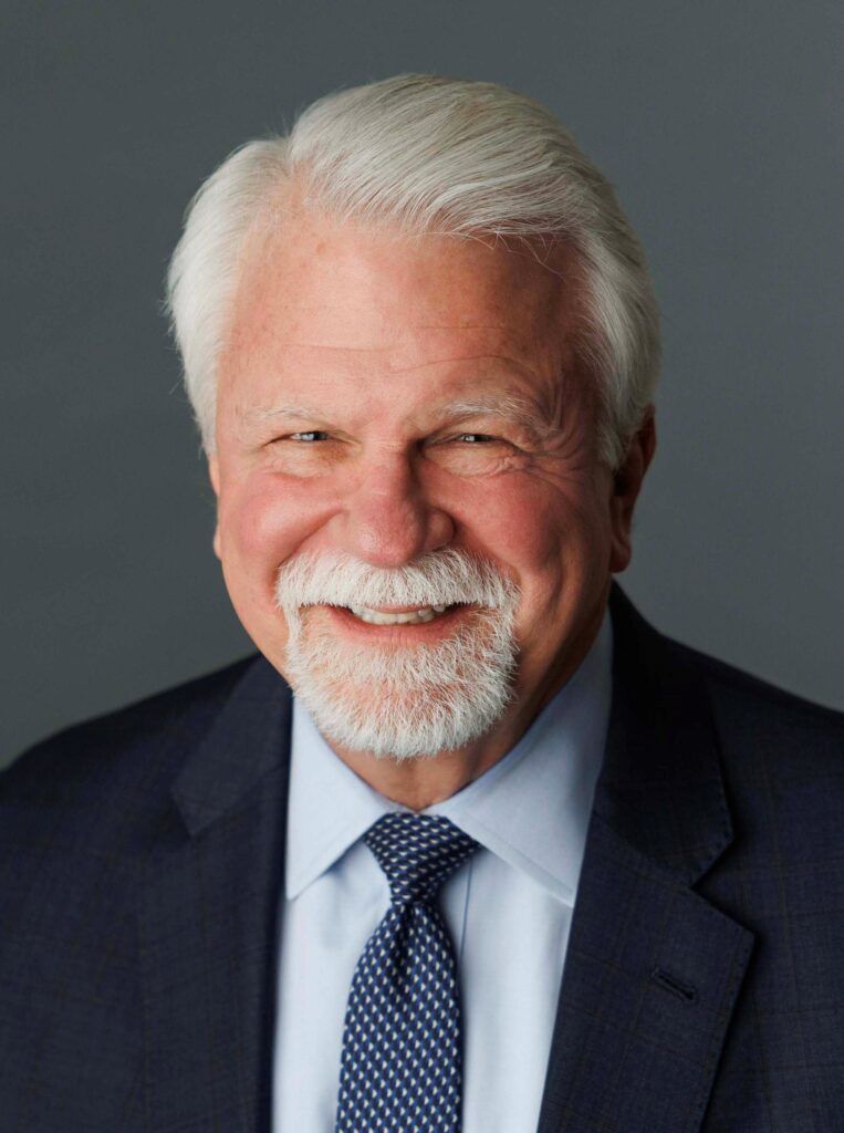 a man in a suit and tie is smiling for the camera