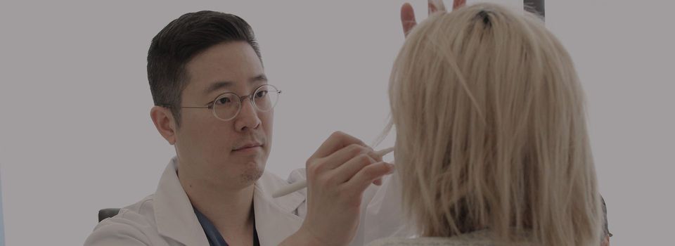 A Grand plastic surgeon marking a patient before facelift surgery