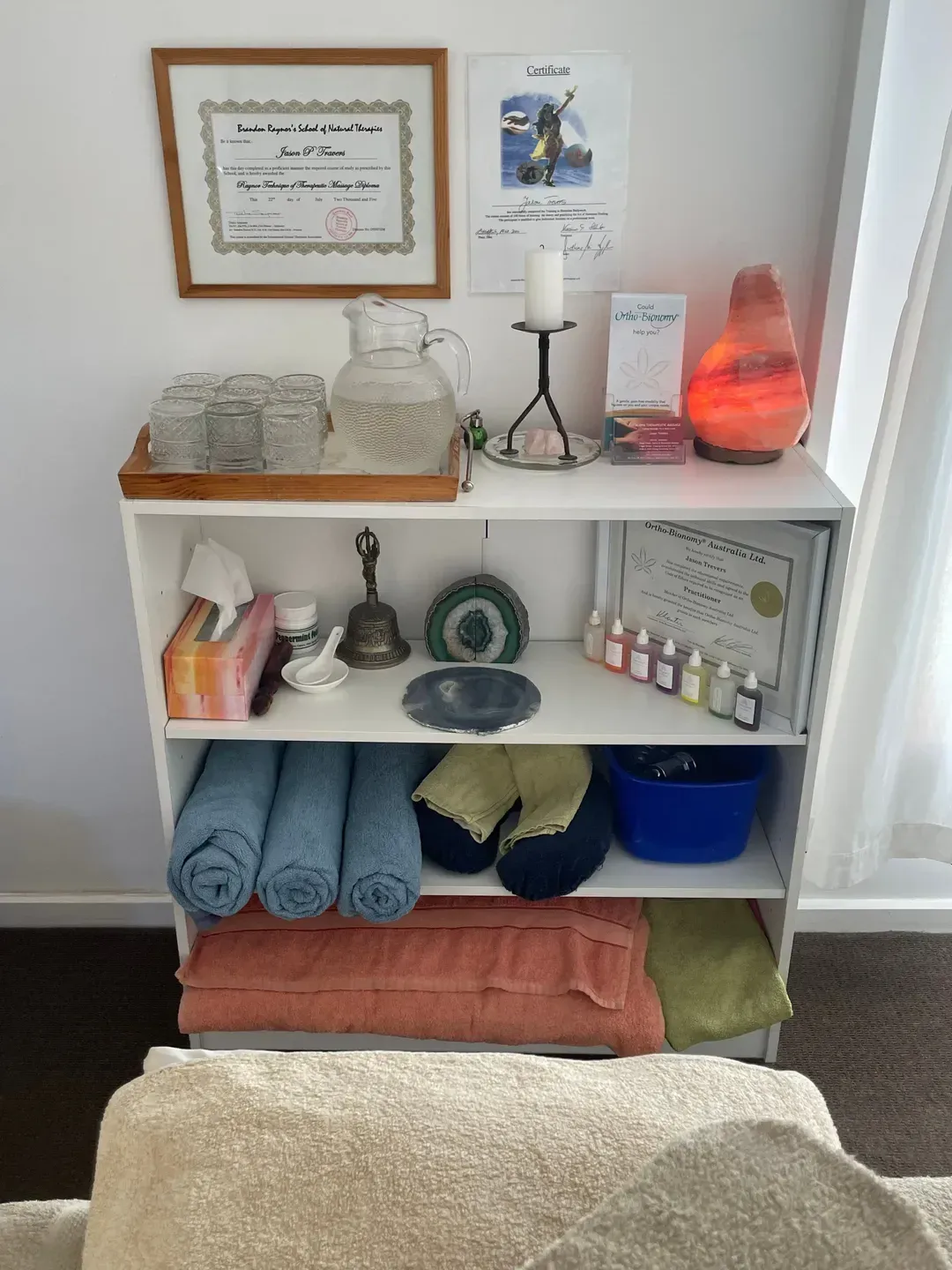 A shelf filled with towels , candles , and other items โ Aloha Therapeutic Massage In Gillen, NT