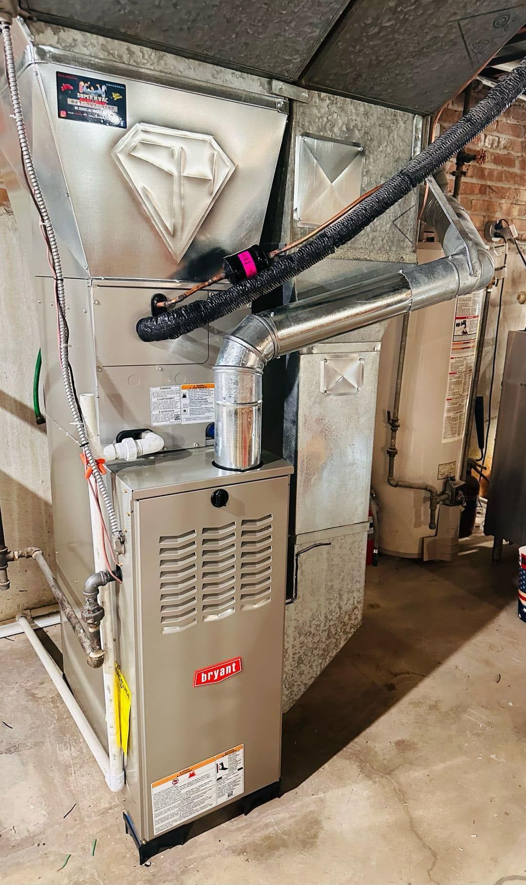 Basement furnace and HVAC ductwork with insulated pipes and white walls
