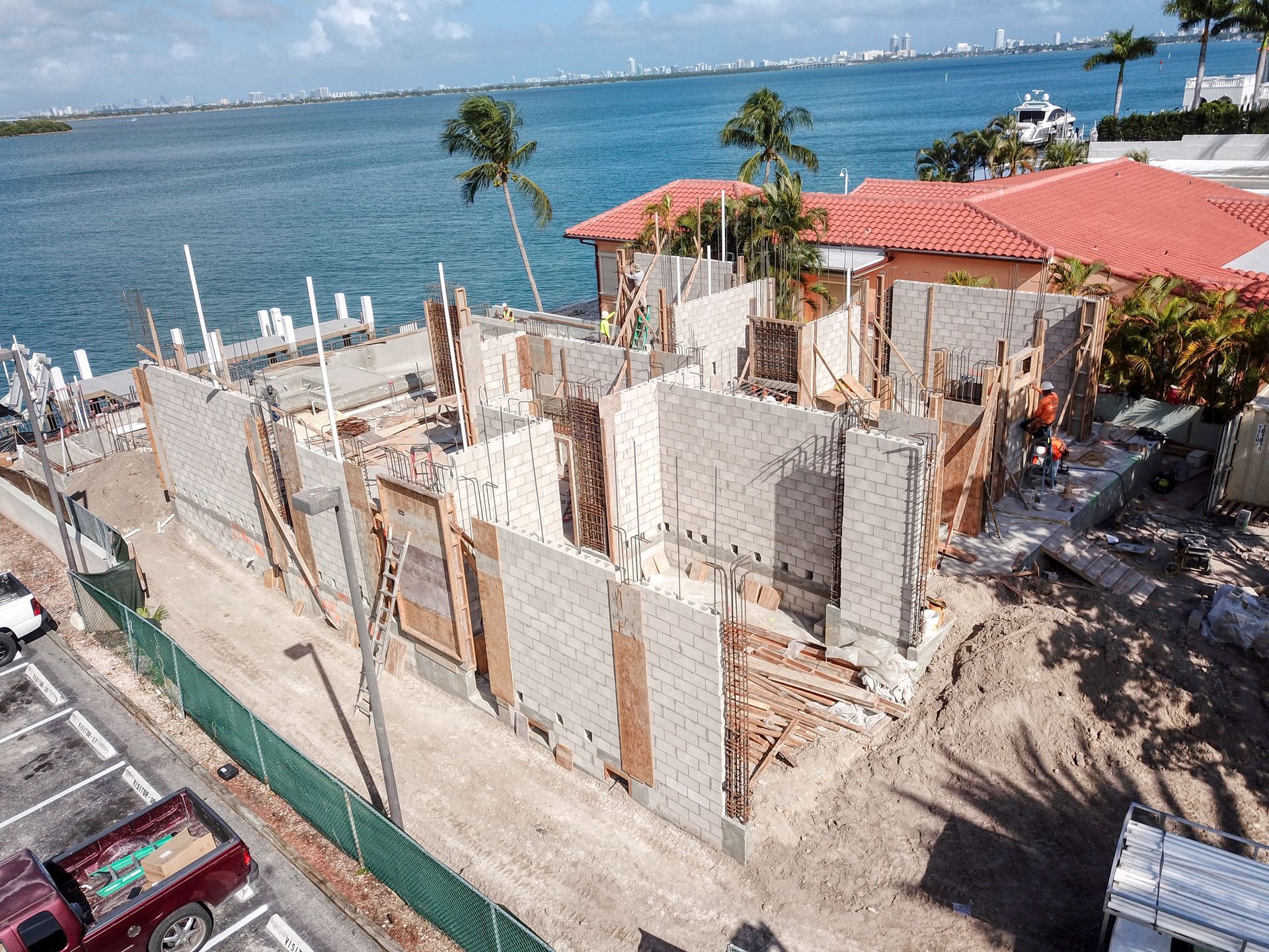 An aerial view of a building under construction next to a body of water.