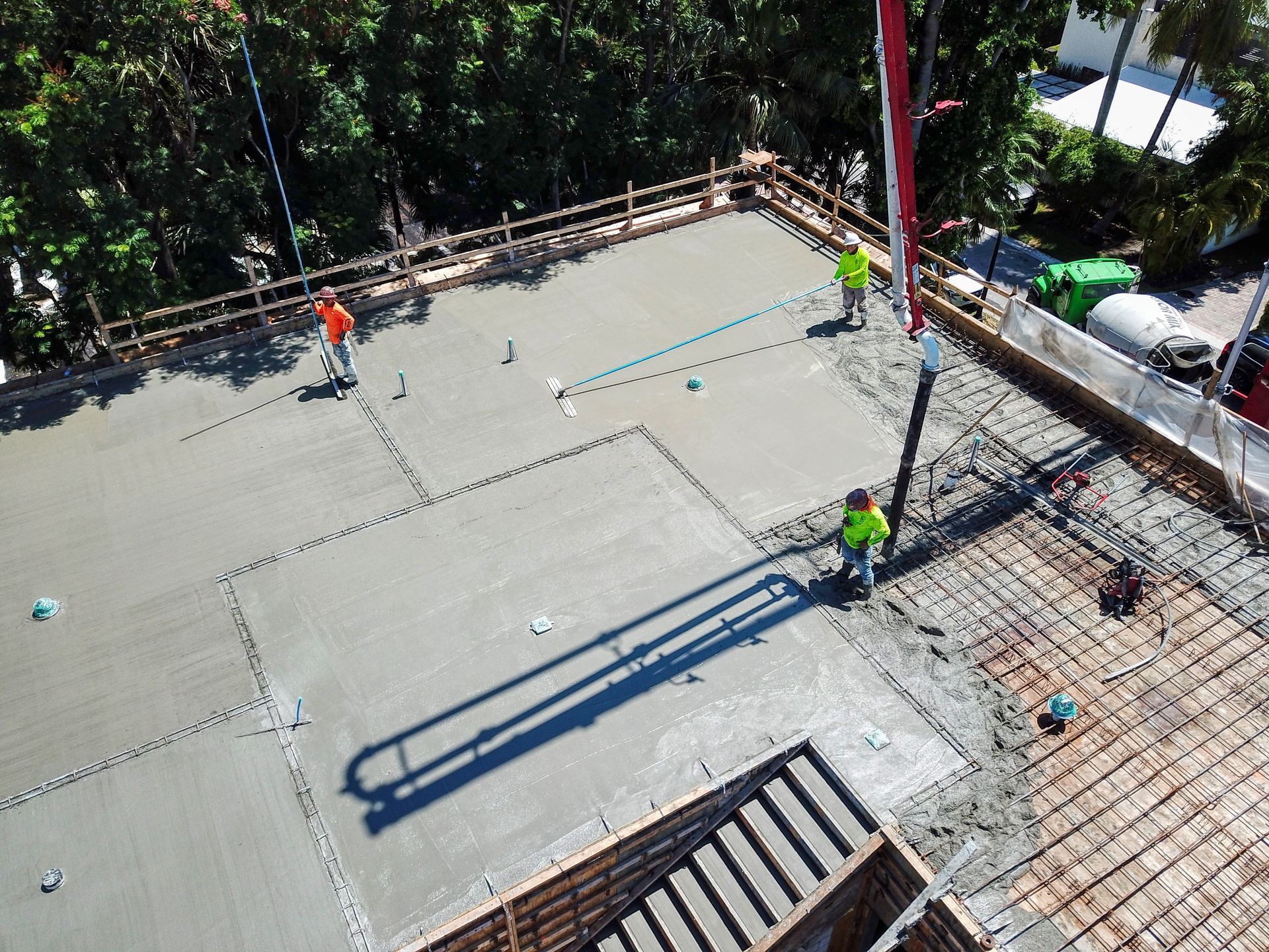 A group of construction workers are working on a concrete floor.