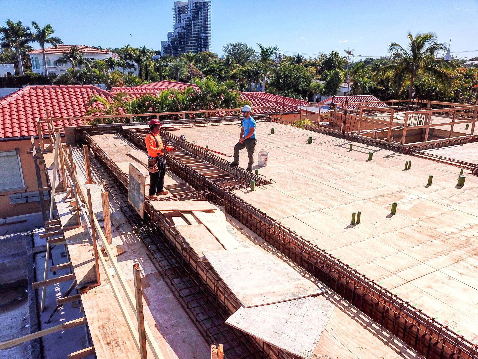 A group of construction workers are working on the roof of a building.