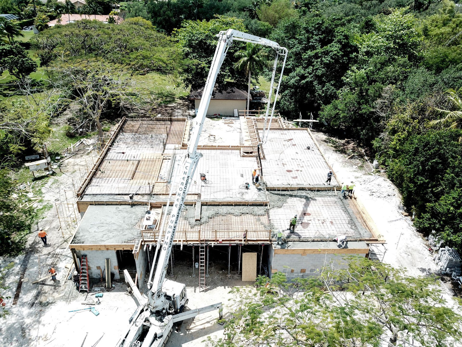 An aerial view of a house under construction with a concrete pump.