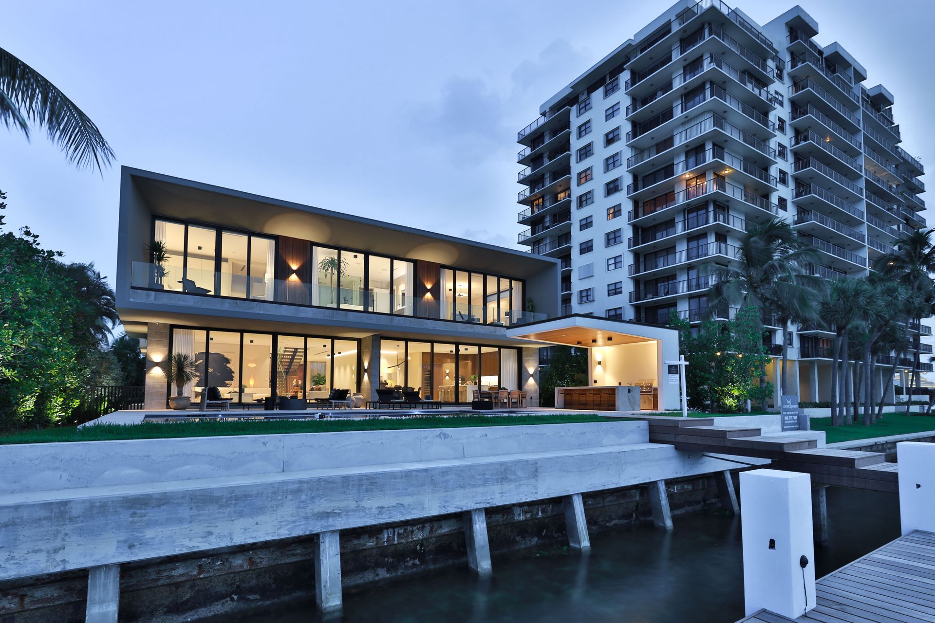A large building with a lot of windows is next to a body of water
