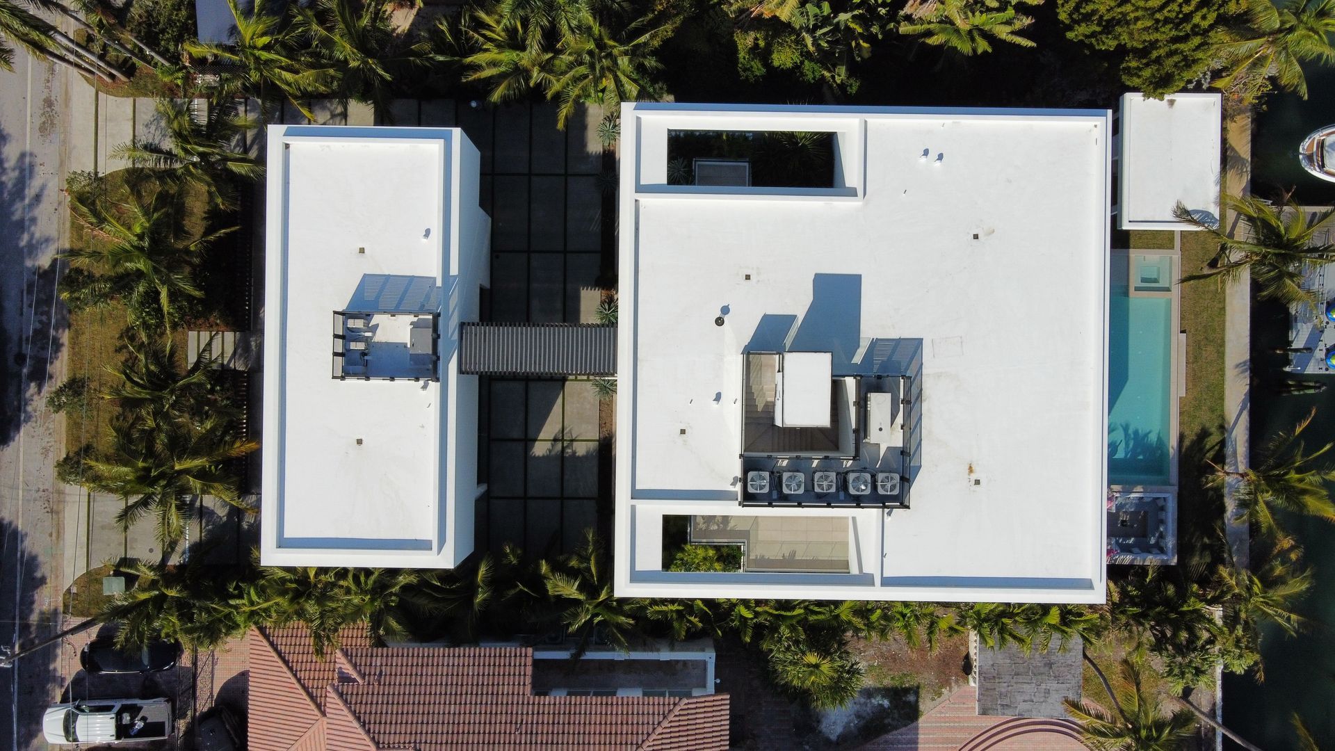 An aerial view of a house with a white roof