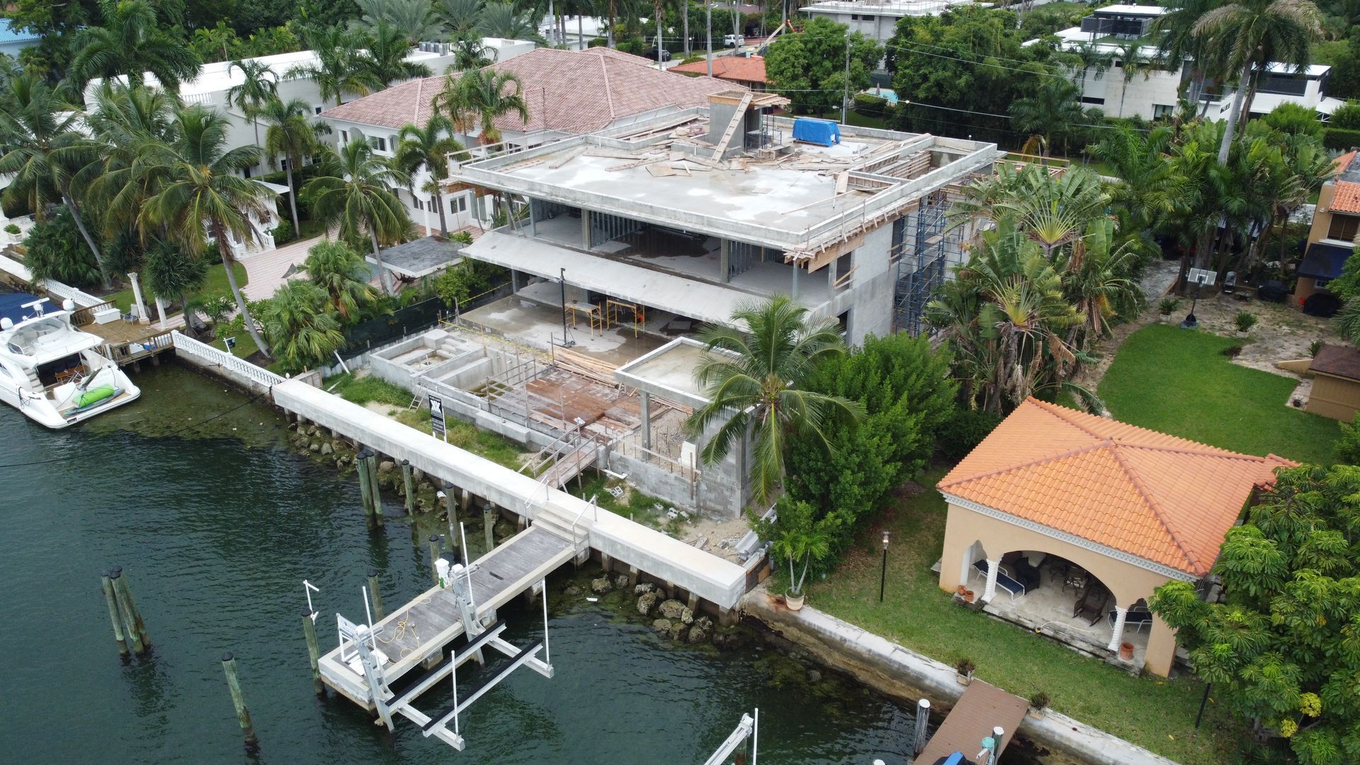 An aerial view of a house under construction next to a body of water.