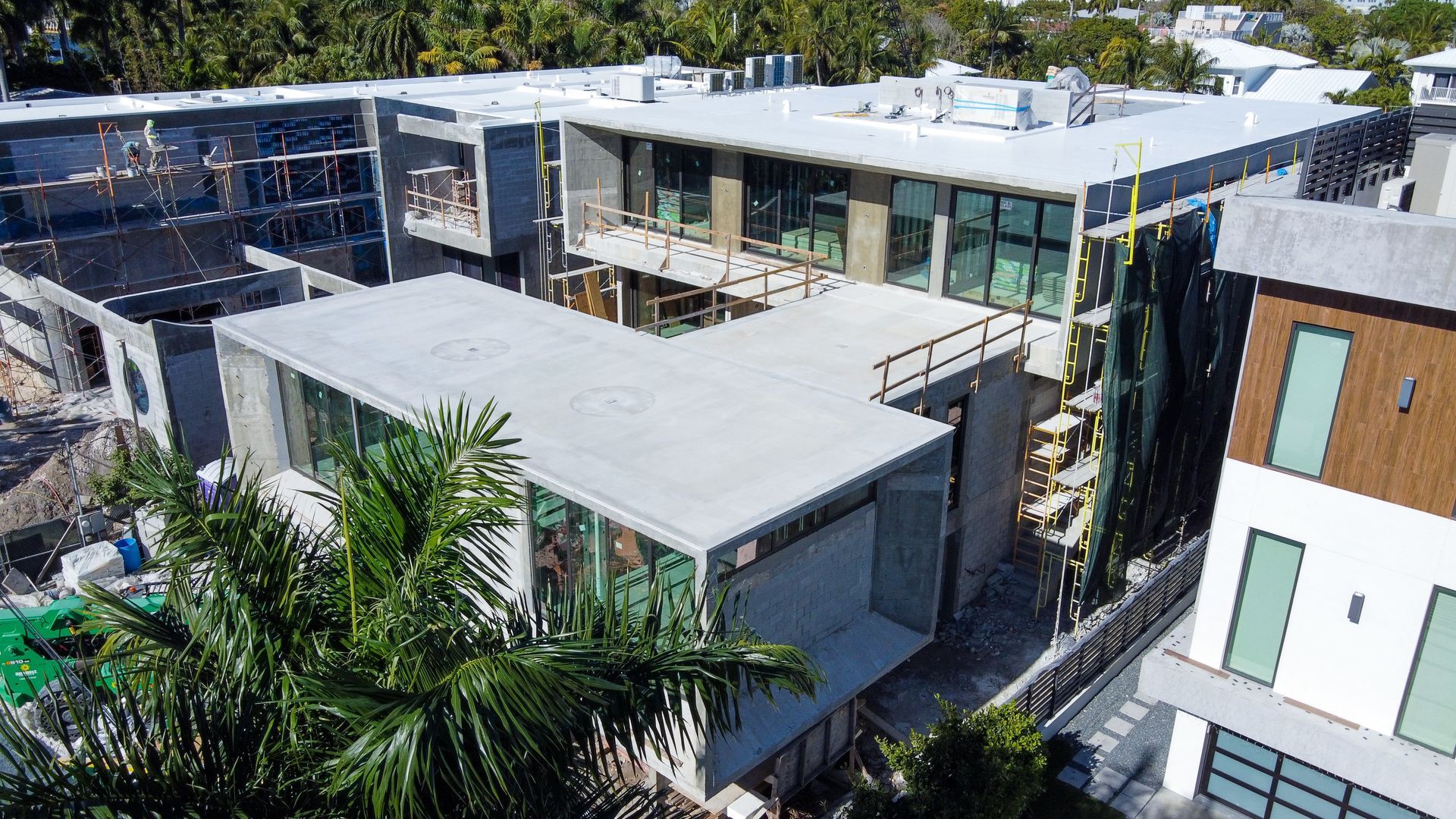 Aerial view of a building under construction, showing wooden framing and workers.