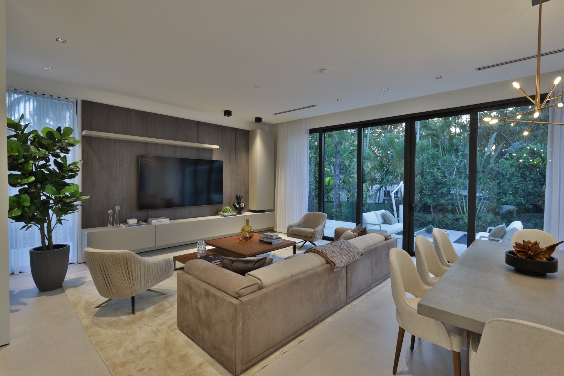 A living room with a couch , chairs , table and television