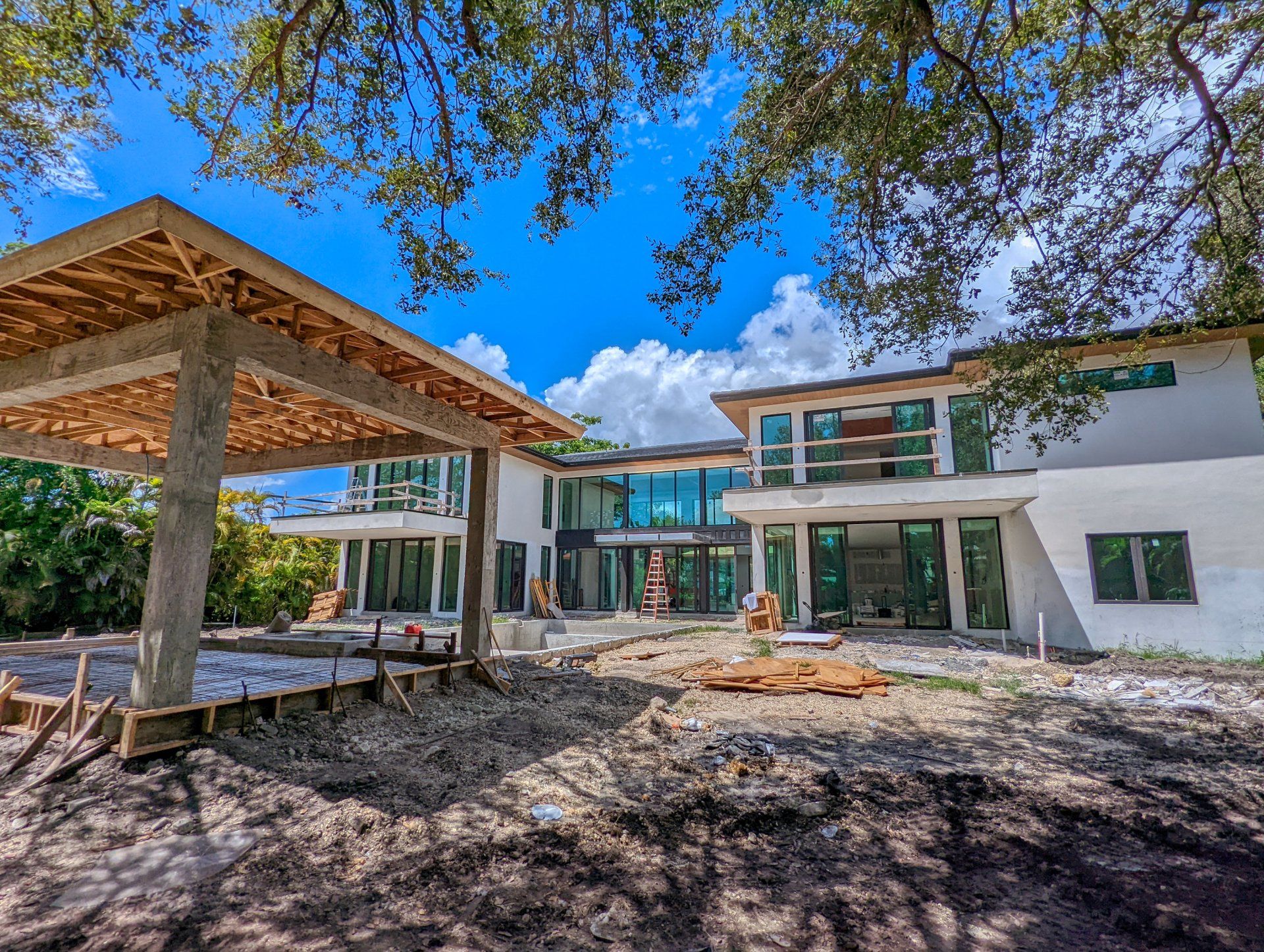 Modern home under construction with covered patio; blue sky backdrop.