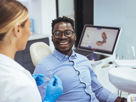 A man is smiling while sitting in a dental chair